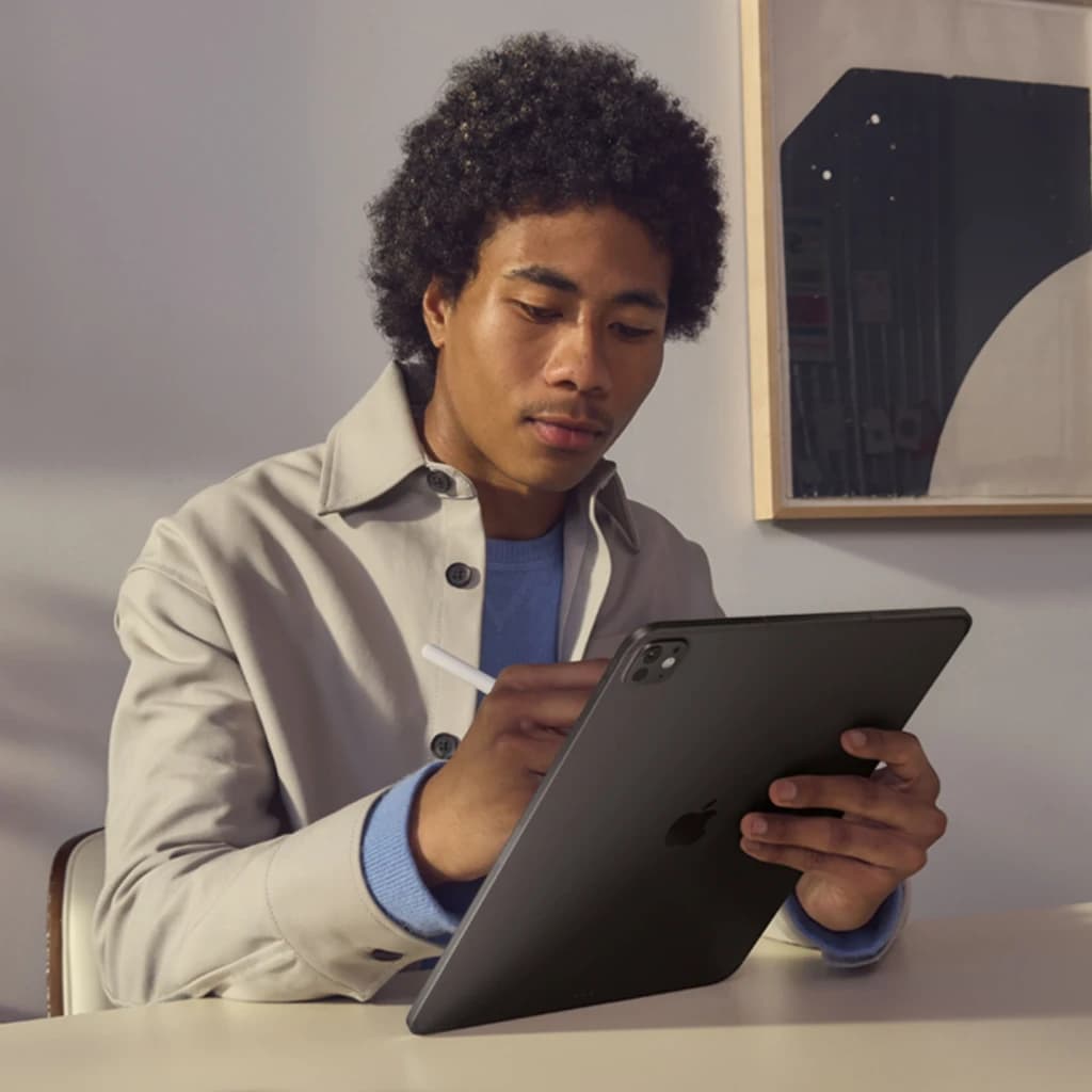 Apple iPad Pro 11 pouces M5 256Go Noir OLED 120Hz Wi-Fi + Cellular - homme tenant la tablette par derrière avec Apple