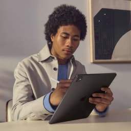 Apple iPad Pro 11 pouces M5 256Go Noir OLED 120Hz Wi-Fi + Cellular - homme tenant la tablette par derrière avec Apple