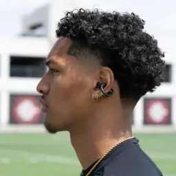 Auriculares JLab Flex ENC TWS In-Ear Bluetooth 5.4 Negro - perfil lateral de hombre con earbud negro en oreja, gancho
