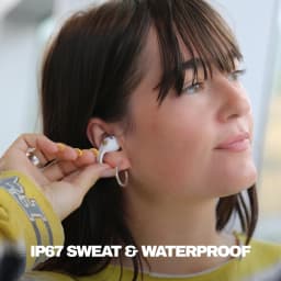 Écouteurs open-ear Skullcandy Push 720 Open Bluetooth 5.3 24h avec étui IP67 Bone/Or - femme plaçant l'écouteur