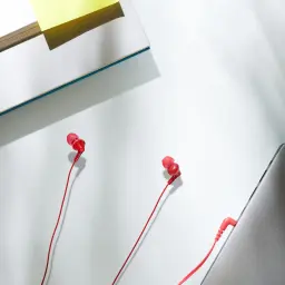 Auriculares Panasonic In-Ear Jack 3,5mm Vermelho RP-HJE125 - dois auriculares sobre superfície com livro