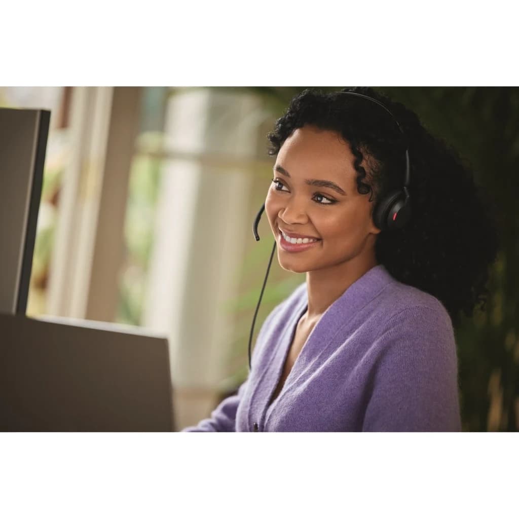 Adaptador Jabra Engage 50 II Link UC USB-C - mujer con auricular Jabra puesto frente a monitor en oficina