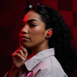 Écouteurs sans fil Skullcandy Method 360 ANC Réduction de Bruit TWS Rouge - femme portant un écouteur rouge, fond