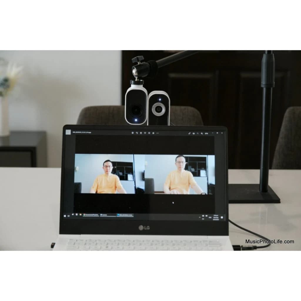 Webcam Creative Project Watcher 4K Microfone Branco - montada em braço articulado sobre portátil com dupla vista