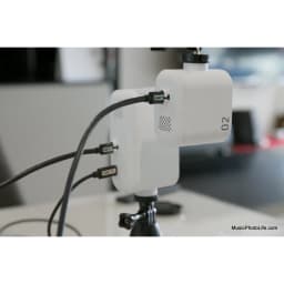 Webcam Creative Project Watcher 4K Microfone Branco - montada em tripé com cabos USB conectados em ambiente