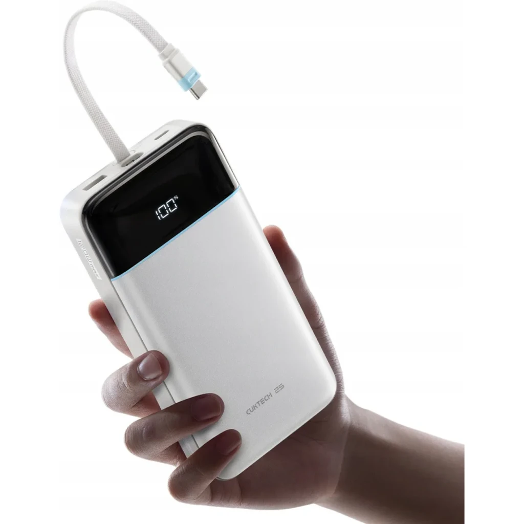 Power Bank Cuktech 25000mAh Blanc Câble USB-C Intégré 120W 3 Ports LPB252N, en main: écran LED à 100% et câble tressé déployé