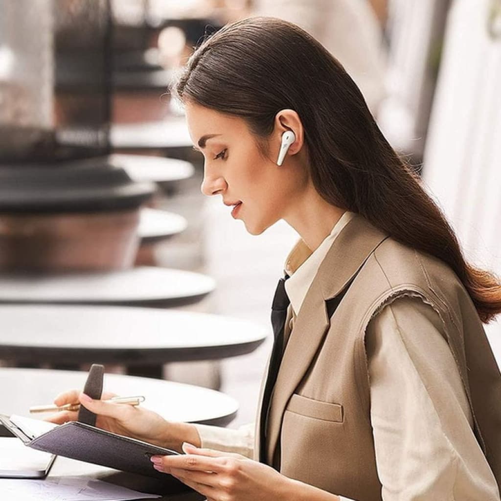 1MORE ComfoBuds Pro Blanc Écouteurs Bluetooth Déscellés portés par une femme élégante, design blanc épuré à tige, ajustement intra-auriculaire