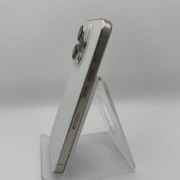 iPhone 15 Pro 5G 256Go Titane Blanc, état excellent: dos blanc mat, bords titane brossé, triple module photo pro, design fin posé sur support transparent.