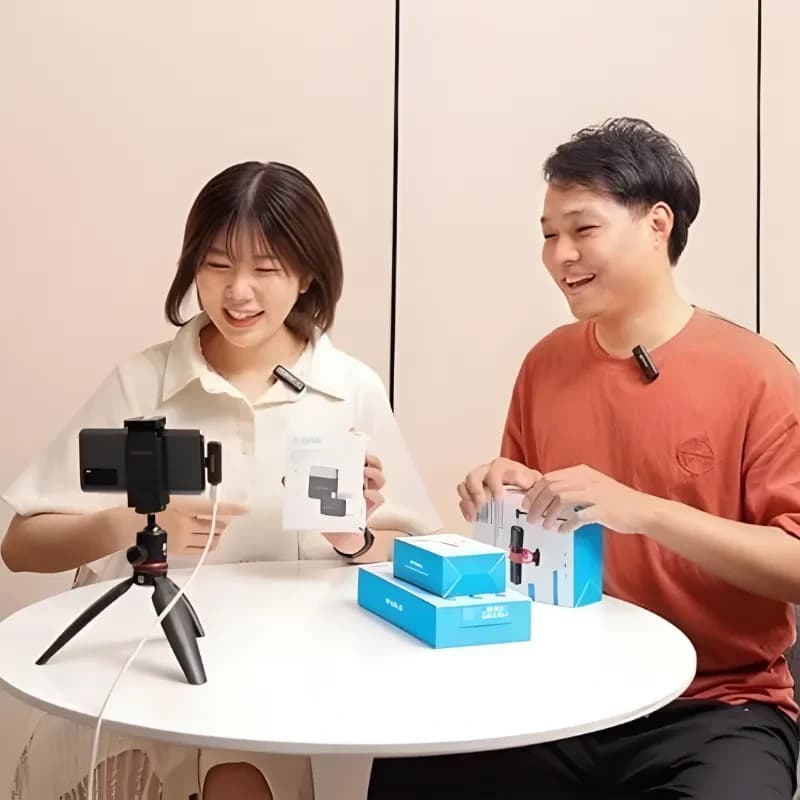 Boya BY-WM3T2-U2 avec deux micros cravate sans fil 2,4 GHz et récepteur USB-C, clips sur col, tournage mobile sur trépied, boîtes et accessoires visibles