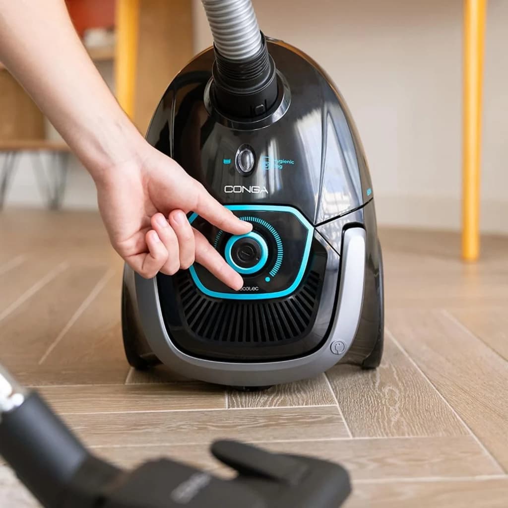 Aspirador Cecotec Conga Powerbag 2500 Plus negro con dial de potencia iluminado en azul, manguera flexible y cabezal de suelo; diseño compacto con bolsa