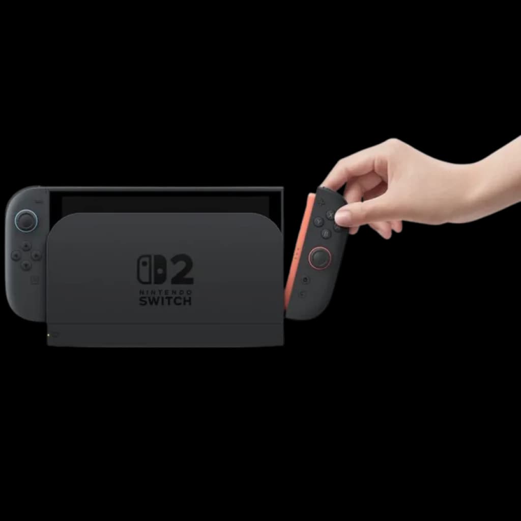 Consola Nintendo Switch 2 en base dock negra con joycon derecho rojo siendo retirado por una mano; pantalla a la izquierda y logotipo 2 en el dock