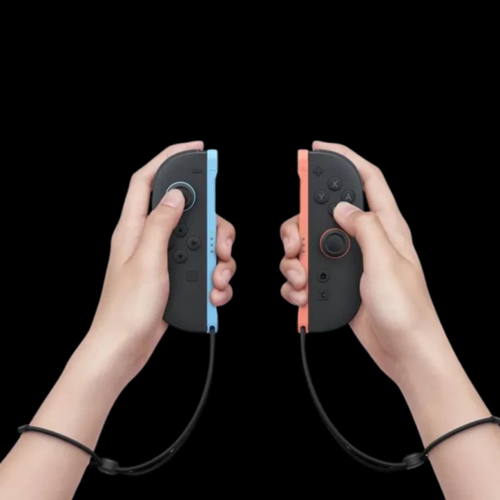 Nintendo Switch 2 Joy Con en manos, uno gris con borde azul y otro negro con borde rojo, botones visibles y correas de muñeca conectadas