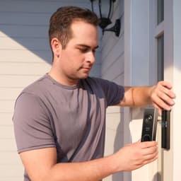 Eufy Security E340 - Sonnette intelligente avec double caméra, boîtier métallique gris, bouton rond lumineux, installation sur montant de porte extérieure