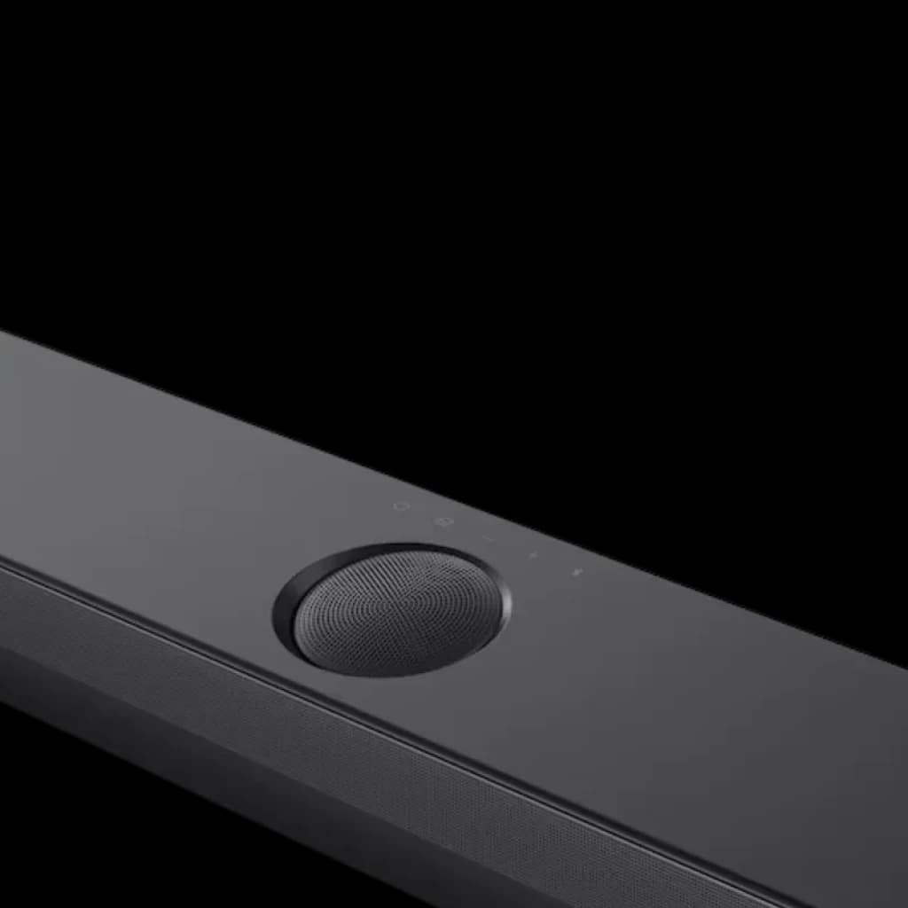 Detalle de la barra LG S70TY negra: control táctil superior, rejilla metálica, dial circular y acabado mate elegante, parte frontal del sistema 3.1.1