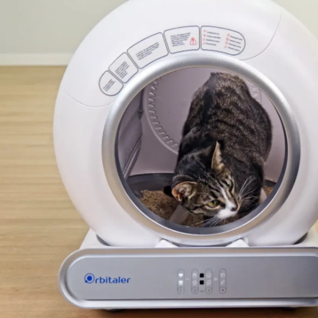 Vista frontal do Orbitaler Yupiter AstroClean 6600 Smart Litter Compact, com imagem de um gato e smartphone com aplicação compatível - Item3