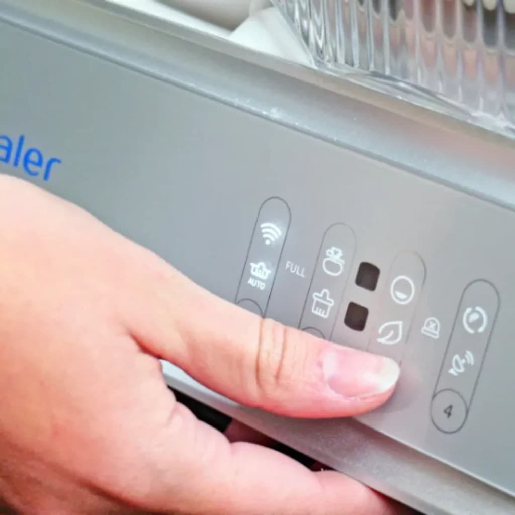 Panel de control del Orbitaler Yupiter AstroClean 6600 Smart Litter Compact, con imagen de una mano como referencia de tamaño