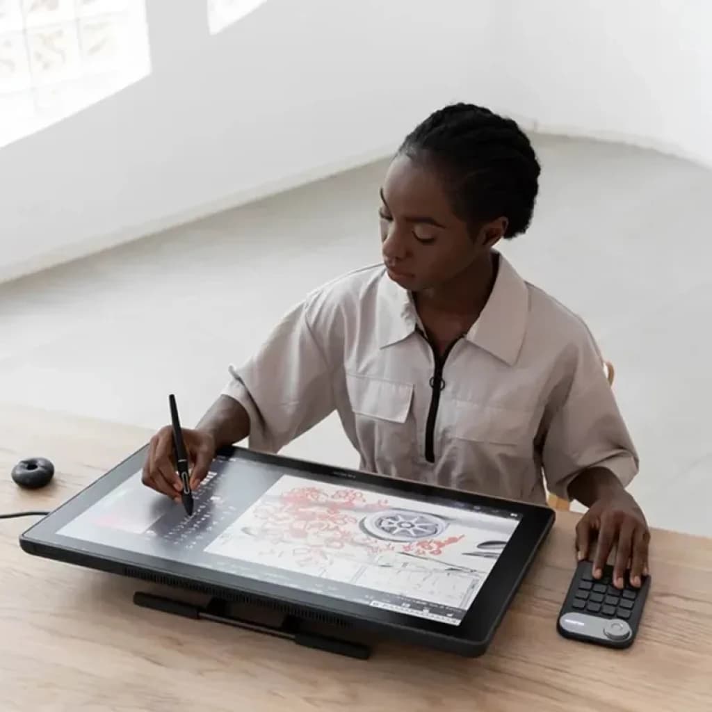 Artiste utilisant la Huion Kamvas 24 Plus GS2402, grand écran 23,8 pouces 2,5K affichant des couleurs 16,7 M, stylet en main et clavier express à côté