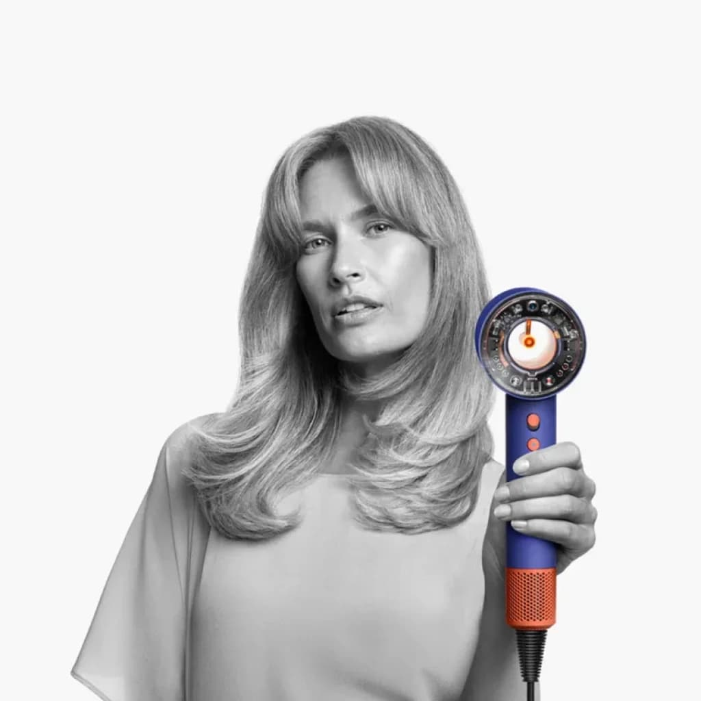 Dyson Supersonic Nural HD16 Ceramic Blue, secador azul con boquilla circular abierta, detalles naranjas, rejilla metálica y cable negro ajustado al mango