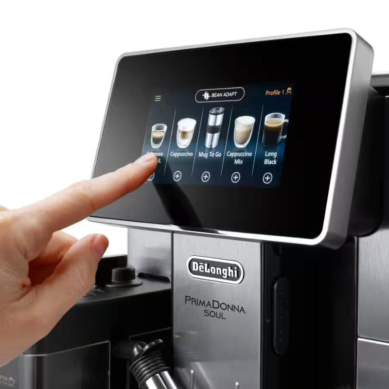 DeLonghi PrimaDonna Soul ECAM 610.55.SB jarra de leite removível sendo preenchida, tampa preta com bocal, tubo de vapor e display touchscreen com bebidas