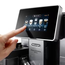 DeLonghi PrimaDonna Soul ECAM 610.55.SB jarra de leite removível sendo preenchida, tampa preta com bocal, tubo de vapor e display touchscreen com bebidas