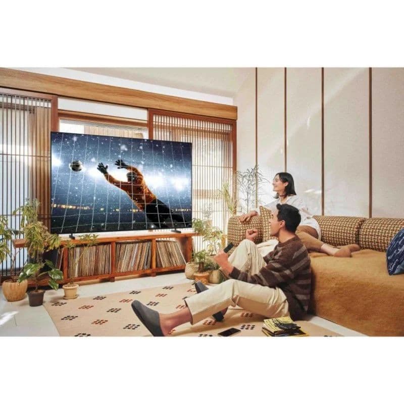 Samsung TU85U8005FU 85" 4K UHD: grand écran LED plat, cadre fin, couleurs vives. Scène sportive nette; téléviseur posé sur meuble bois dans salon moderne.