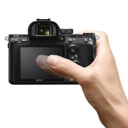 Jeune homme tenant l'appareil photo reflex Sony Alpha 7 III Corps MILC Noir d'une main