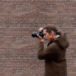 Jeune homme prenant une photo avec l'appareil photo reflex Sony Alpha 7 III Corps MILC Noir