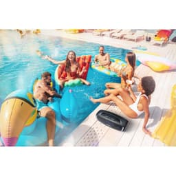 Enceinte Tribit Stormbox Blast 2 noire, boîtier robuste IP67, poignée intégrée, éclairage LED frontal, format allongé, posée au bord d’une piscine