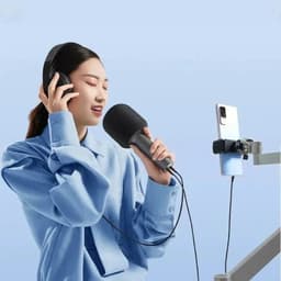 Xiaomi Karaoke Microphone Negro inalámbrico con diseño ergonómico, acabado mate y espuma antipop; se muestra en uso con smartphone y auriculares