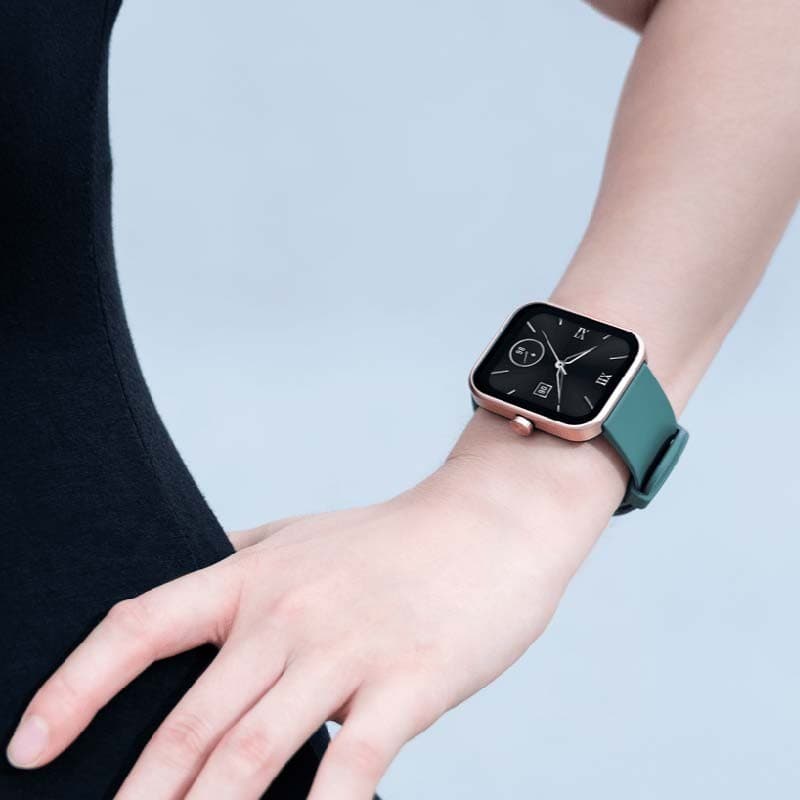 Xiaomi Maimo Watch dourado rosa com pulseira verde; caixa quadrada metálica, tela preta com mostrador minimalista e acabamento elegante no pulso